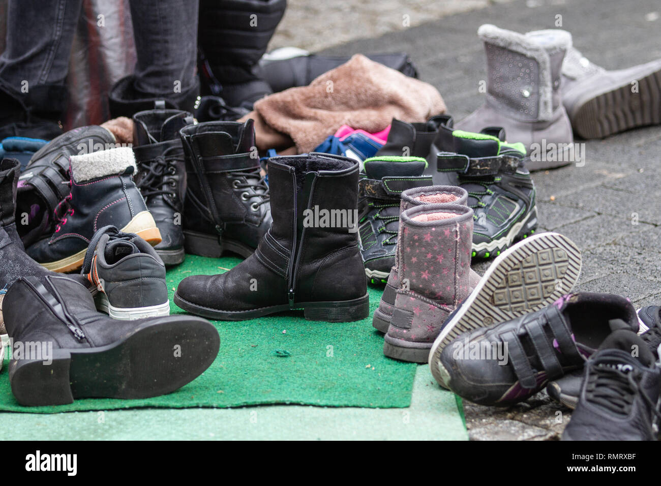 A huddle of boots and shoes taken off  outside Stock Photo