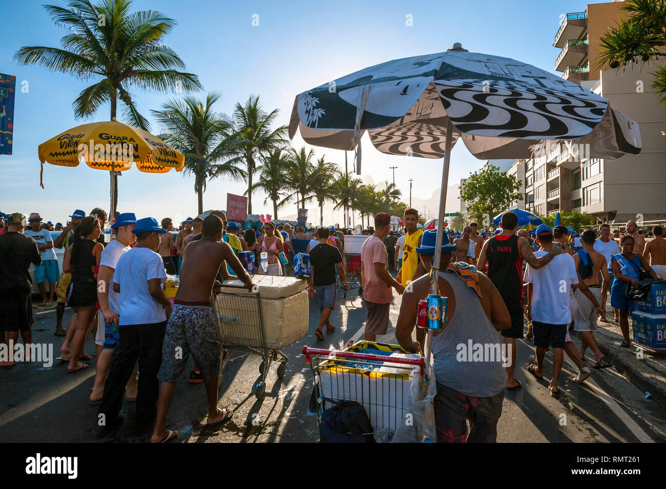 RIO DE JANEIRO - FEBRUARY 28, 2017: Unlicensed Brazilian street vendors compete to serve drinks to crowds celebrating at an afternoon Carnival party. Stock Photo