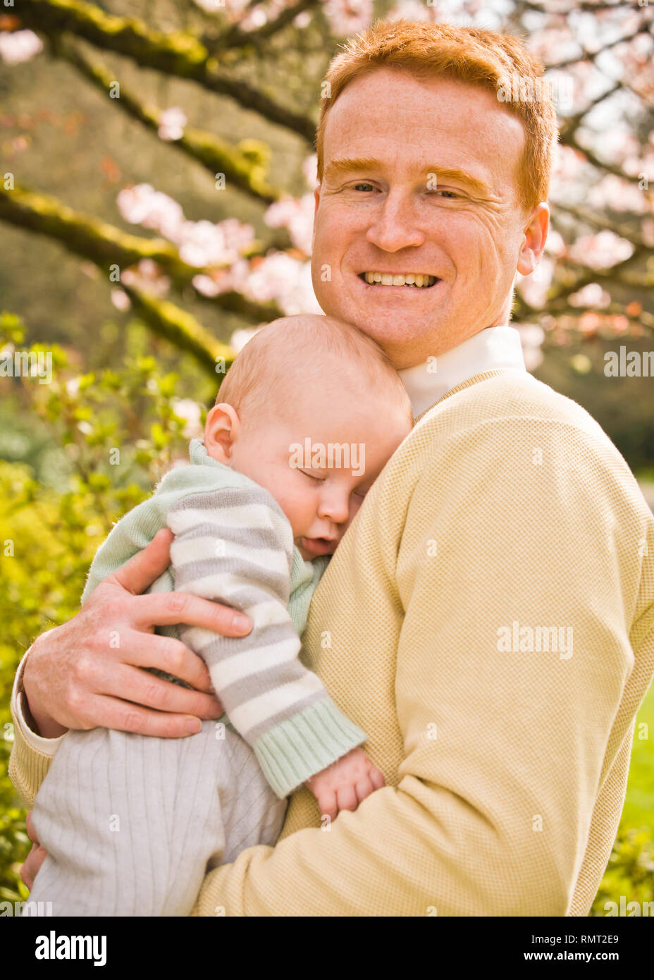 A portrait of a father with his 10 month old son outdoors in a Spring like location. Stock Photo