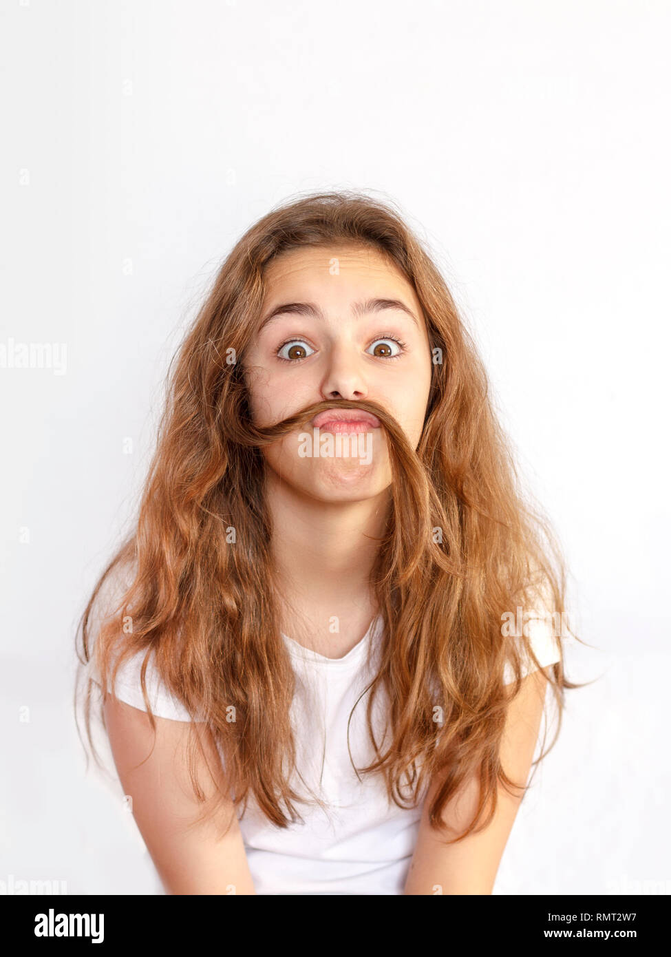 Teen girl fooling around and making mustache out of her hair Stock ...