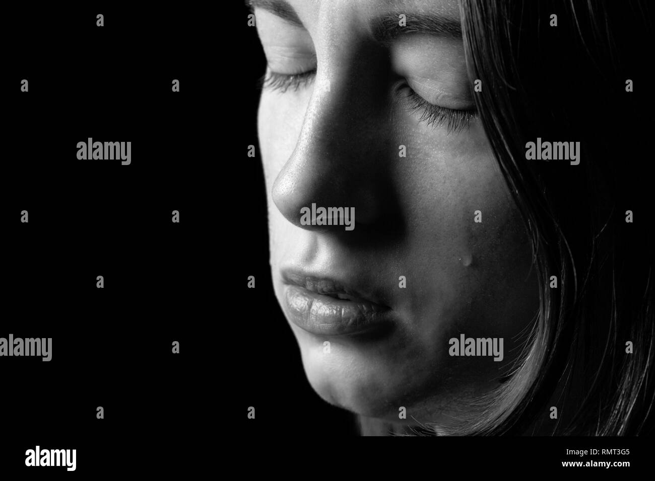 sad woman crying, looking aside on black background, closeup portrait,  profile view, monochrome Stock Photo - Alamy