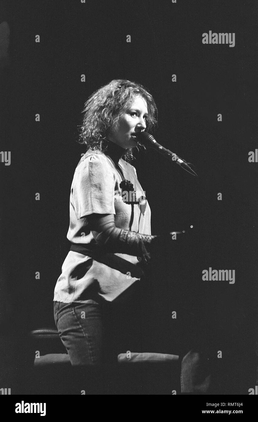 Musician Tori Amos is shown singing at the piano during a 'live' concert performance. Stock Photo