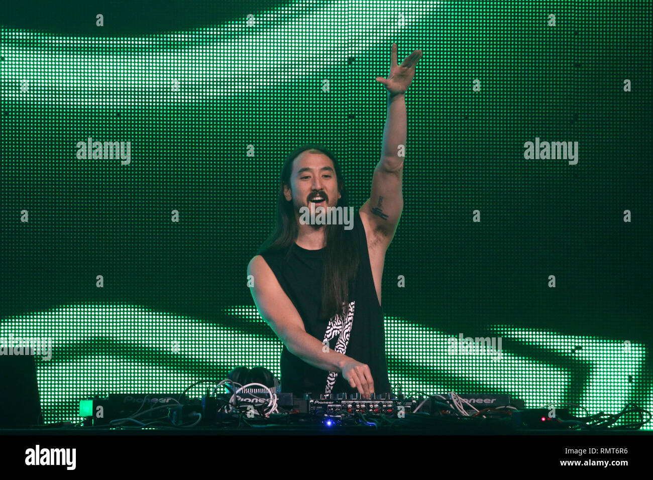 Electro house musician, record producer, club promoter Steve Aoki is shown performing on stage during a sold out concert appearance. Stock Photo