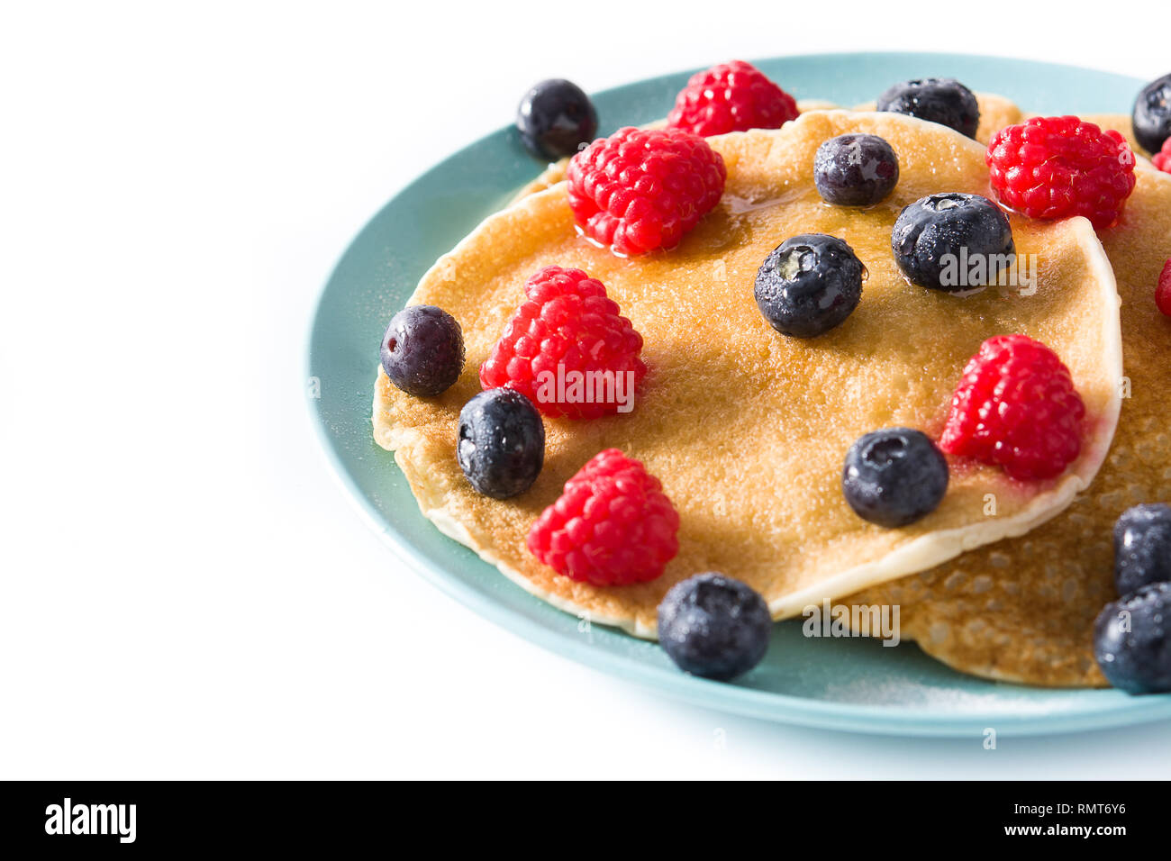 Pancakes with raspberries, blueberries and honey isolated on white ...