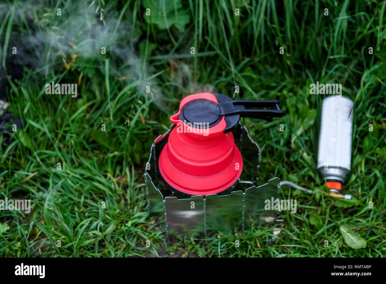 Fodable camping kettle with boiling water standing on burning stove Stock Photo Alamy