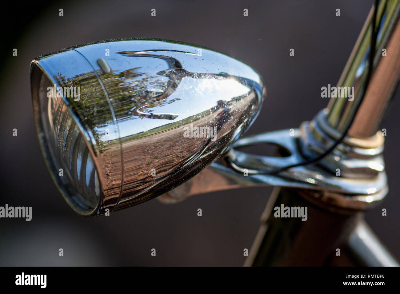 Old fashioned bicycle head lamp with reflection of steering wheel Stock Photo