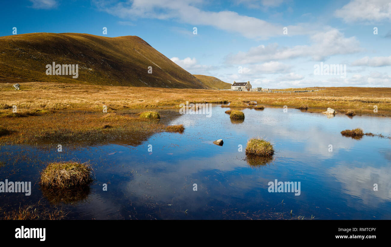 A remote crofthouse on Foula with Hamnafield in the background Stock Photo