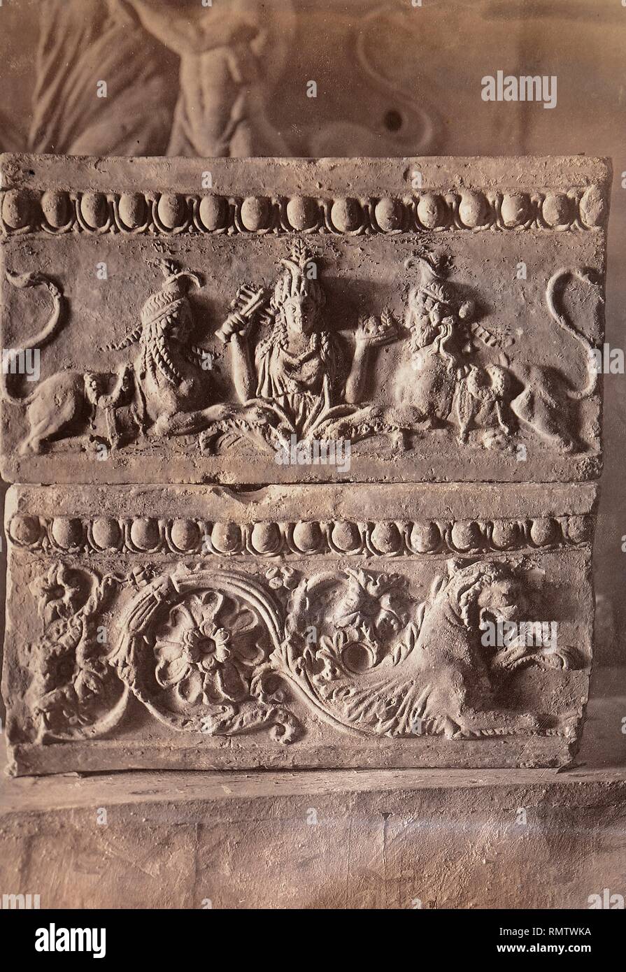 Parte de un friso antiguo, bajorrelieve con figura femenina y esfinges, leones y decoración floral. Stock Photo