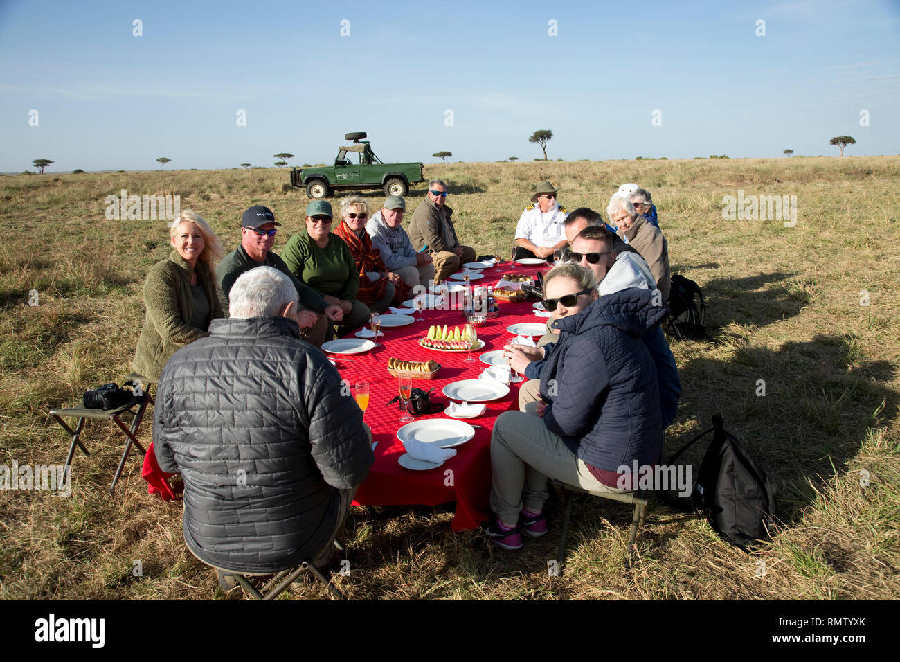 Hot air balloon passengers enjoying bush breakfast set out in grassland