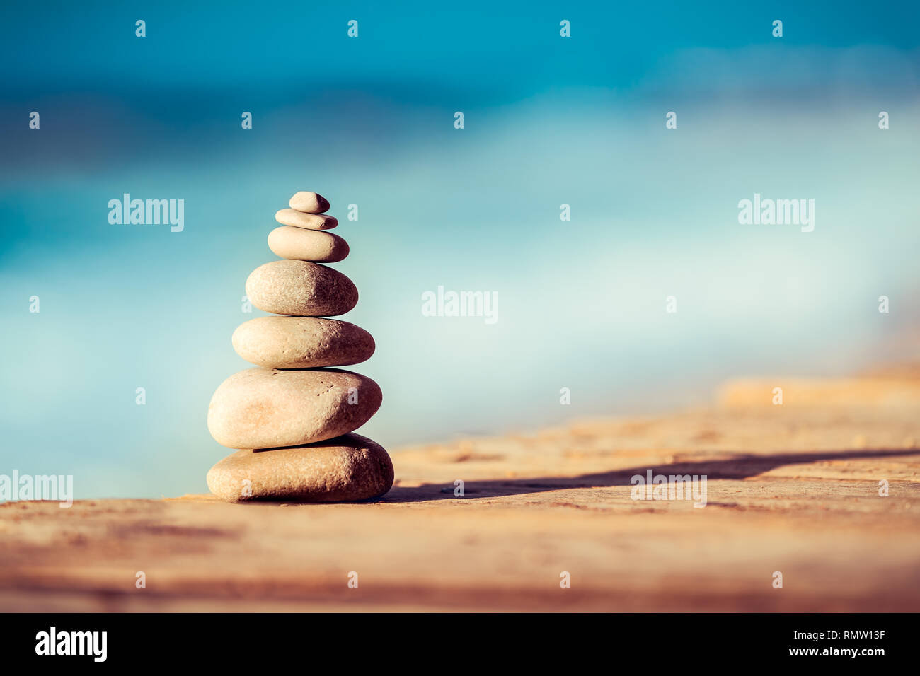 Closeup photo of a pebbles stack on the bridge over sea, spa stones, inner peace and life in balance concept Stock Photo
