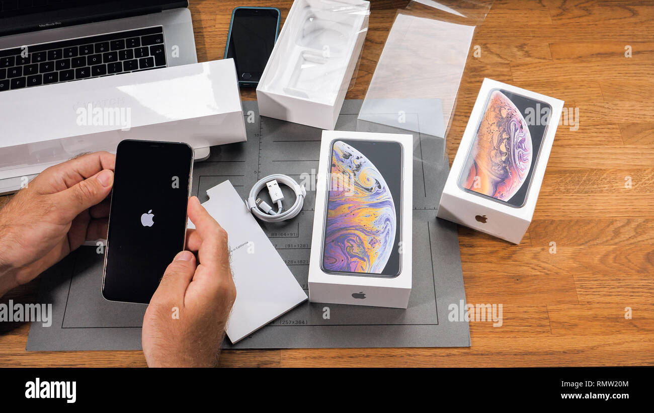 PARIS, FRANCE - SEPTEMBER 21, 2018: Apple fan boy unboxing latest new Apple Iphone Xs Max and Xs flagship smartphone mobile phone model from Apple Computers first run of phone with Apple Logo on display Stock Photo