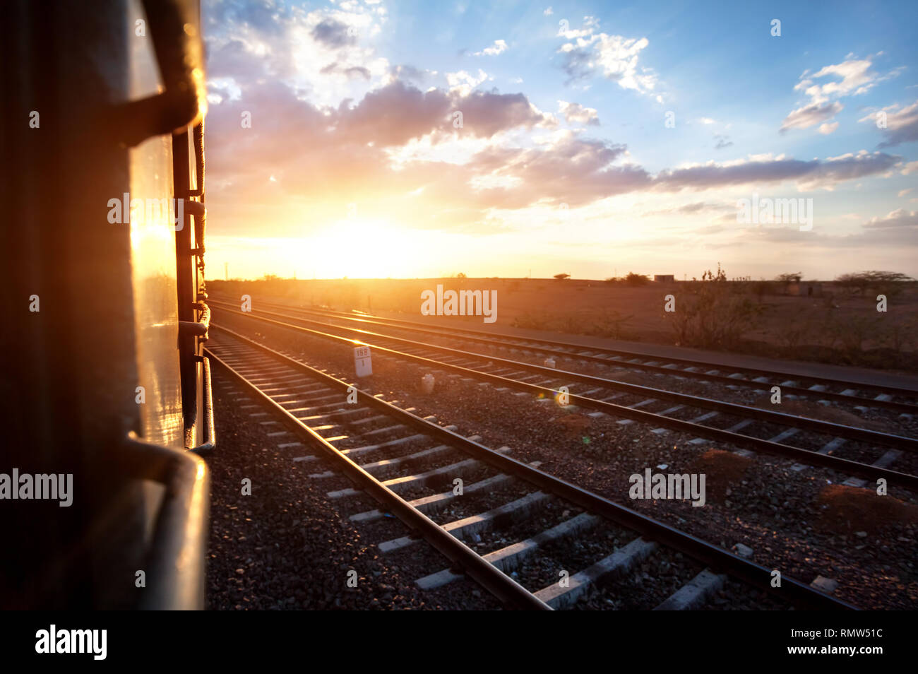 Train passing desert area at sunset sky beckgroung in Rajasthan, India Stock Photo
