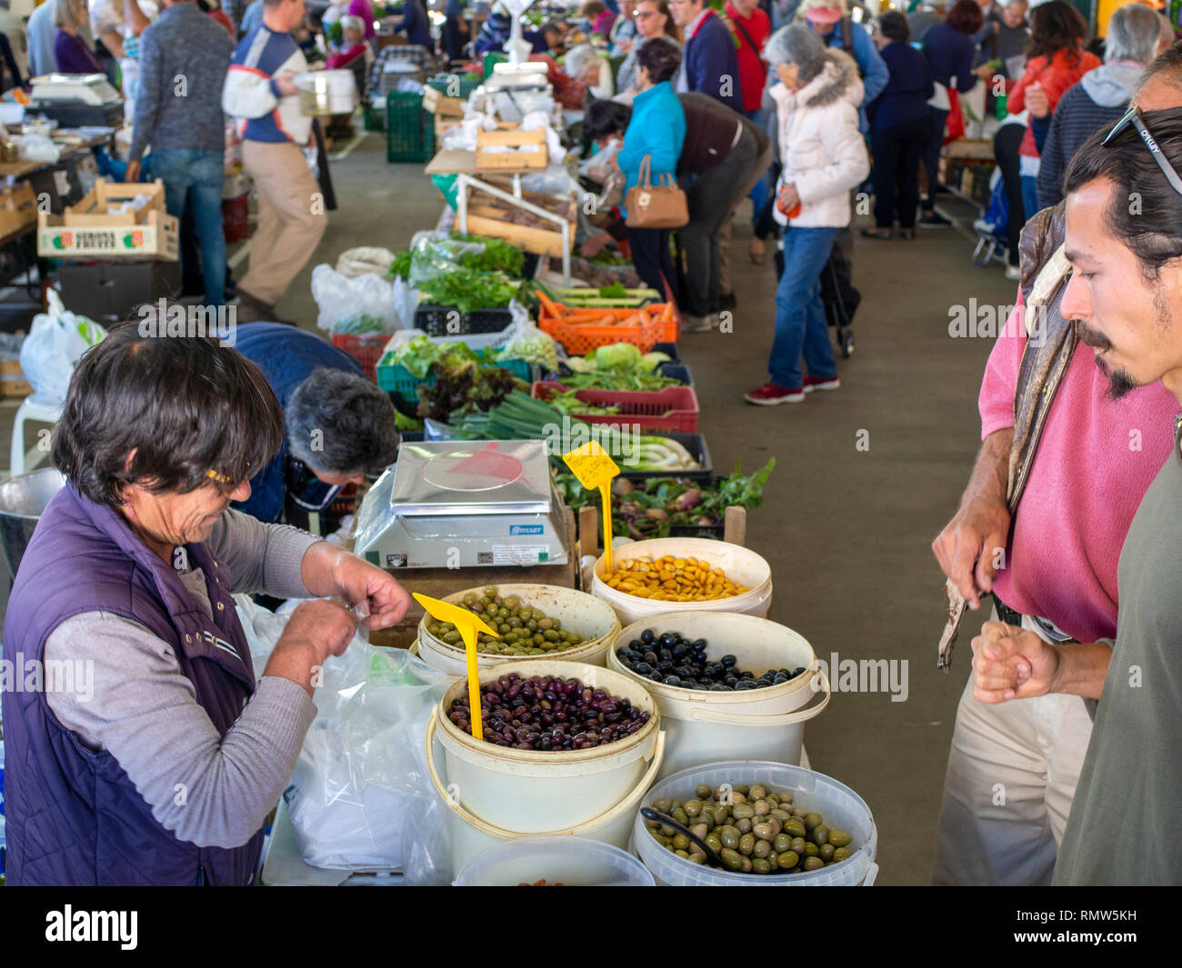 Buying olives at the Lagos Farmer's Market, operating each Saturday at a warehouse at the bus station. Stock Photo