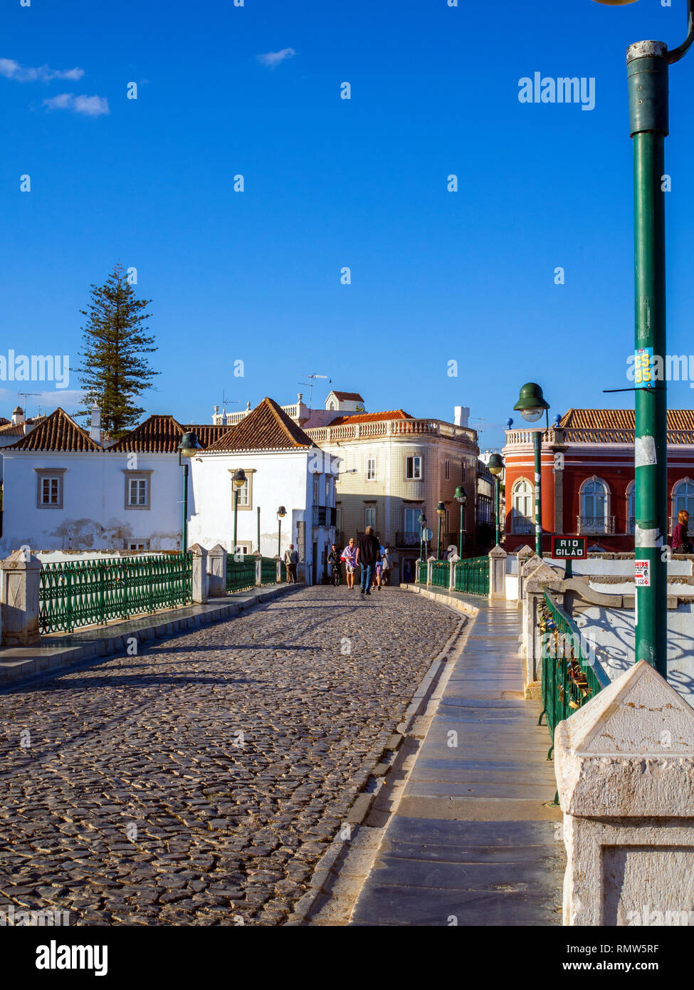 Pedestrians crossing the Roman Bridge in Tavira, a Moorish- built town on the southern coast of Portugal. The bridge is not Roman in origin; it was bu Stock Photo
