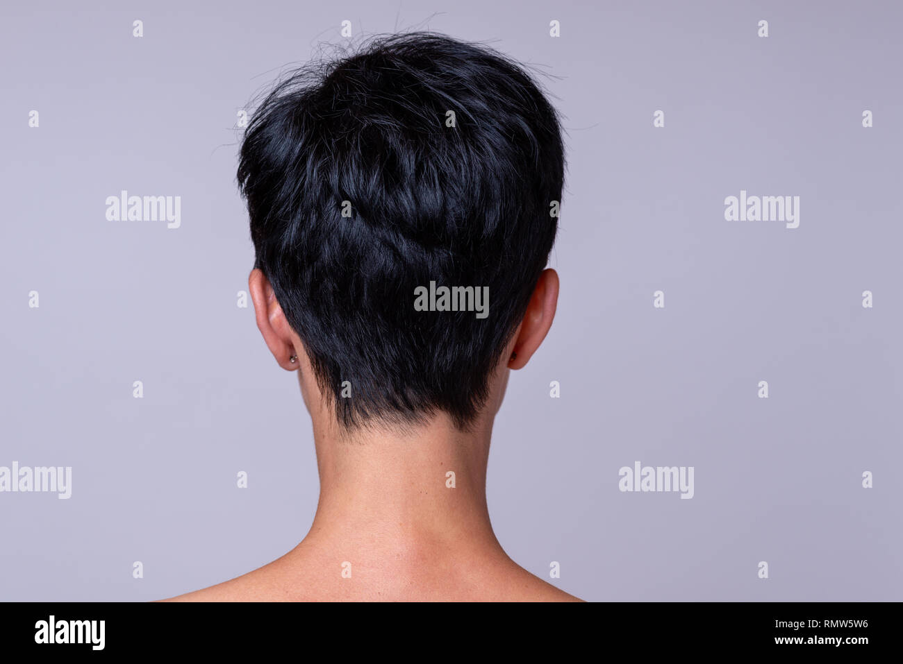 Back View Of A Womans Head In Short Darker Hair Over Neutral