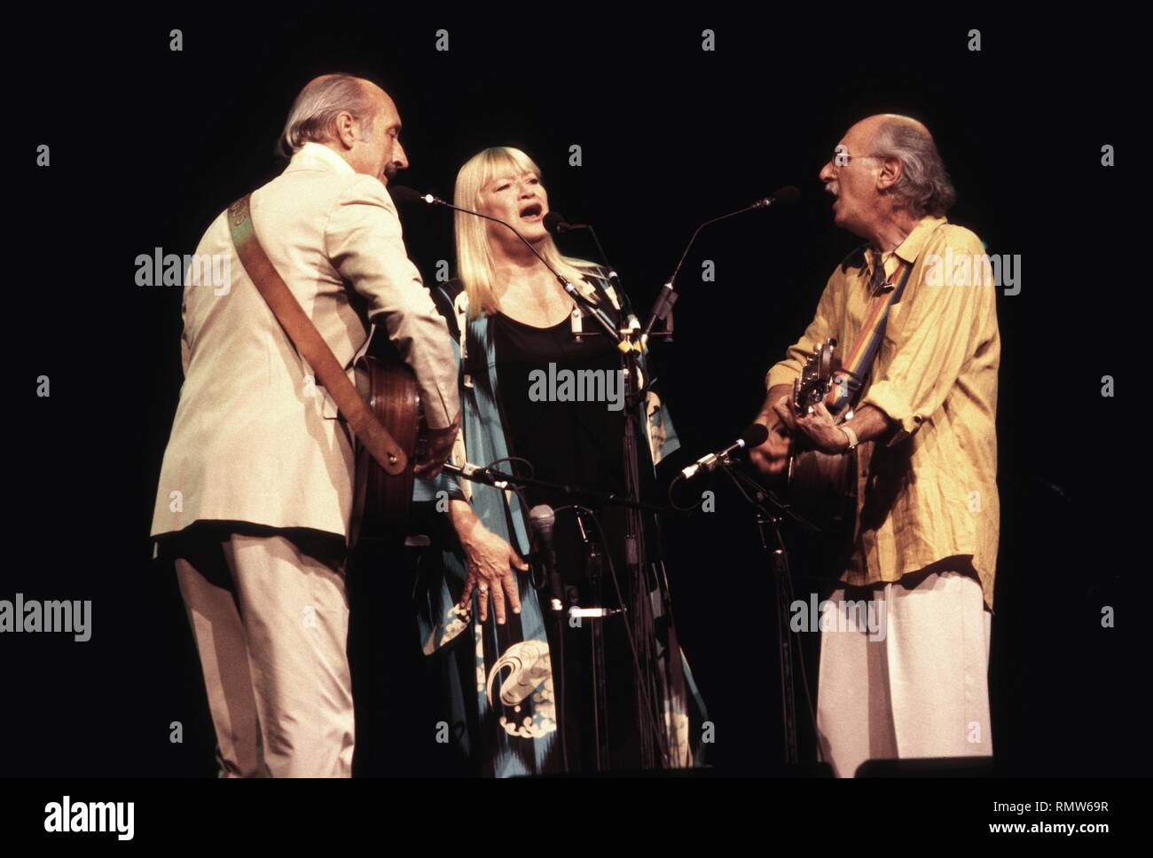 The folk singing trio of Peter, Paul and Mary are shown performing on stage during a "live" concert appearance. Stock Photo