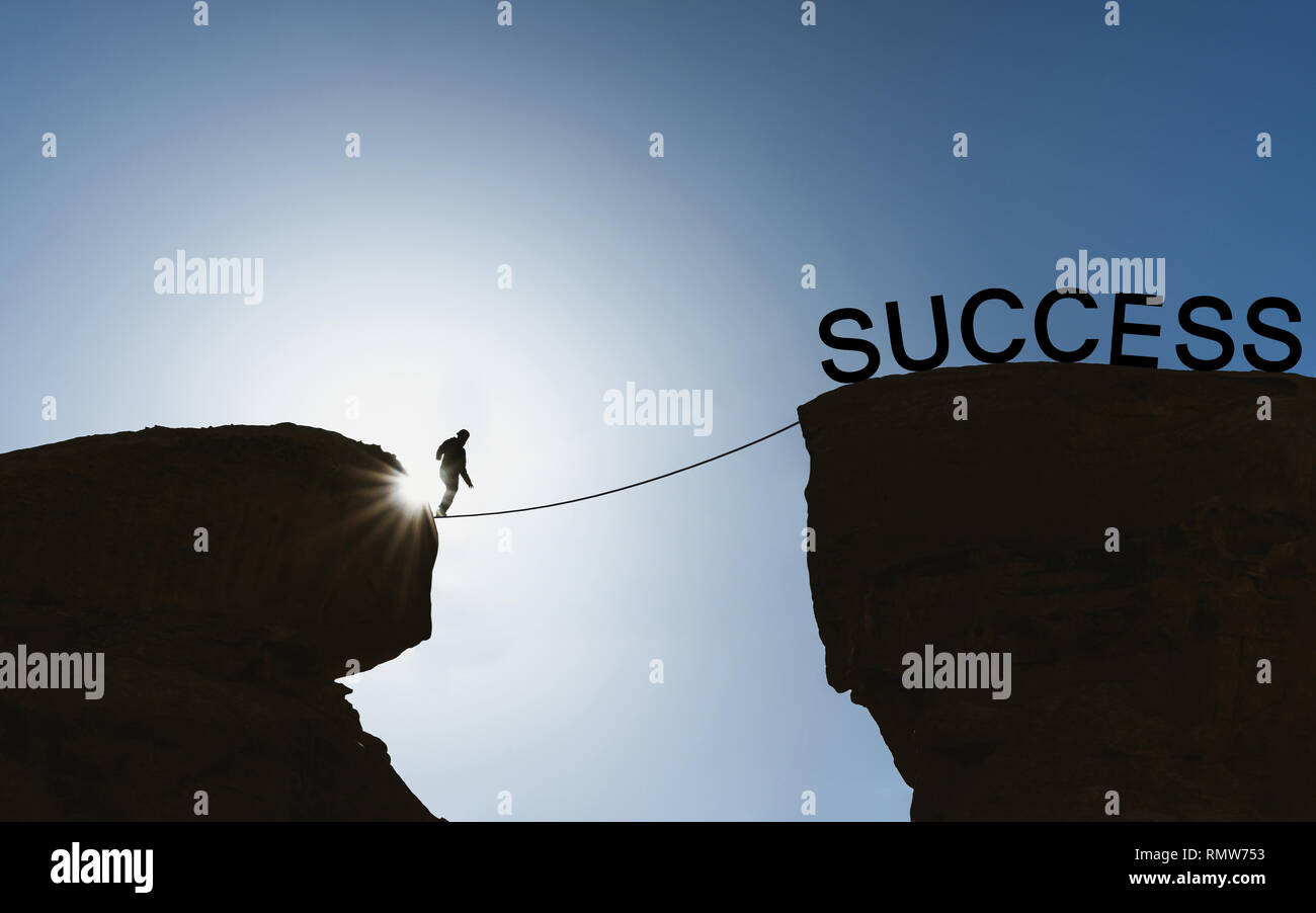 Silhouette a man balancing walking on rope to success Stock Photo