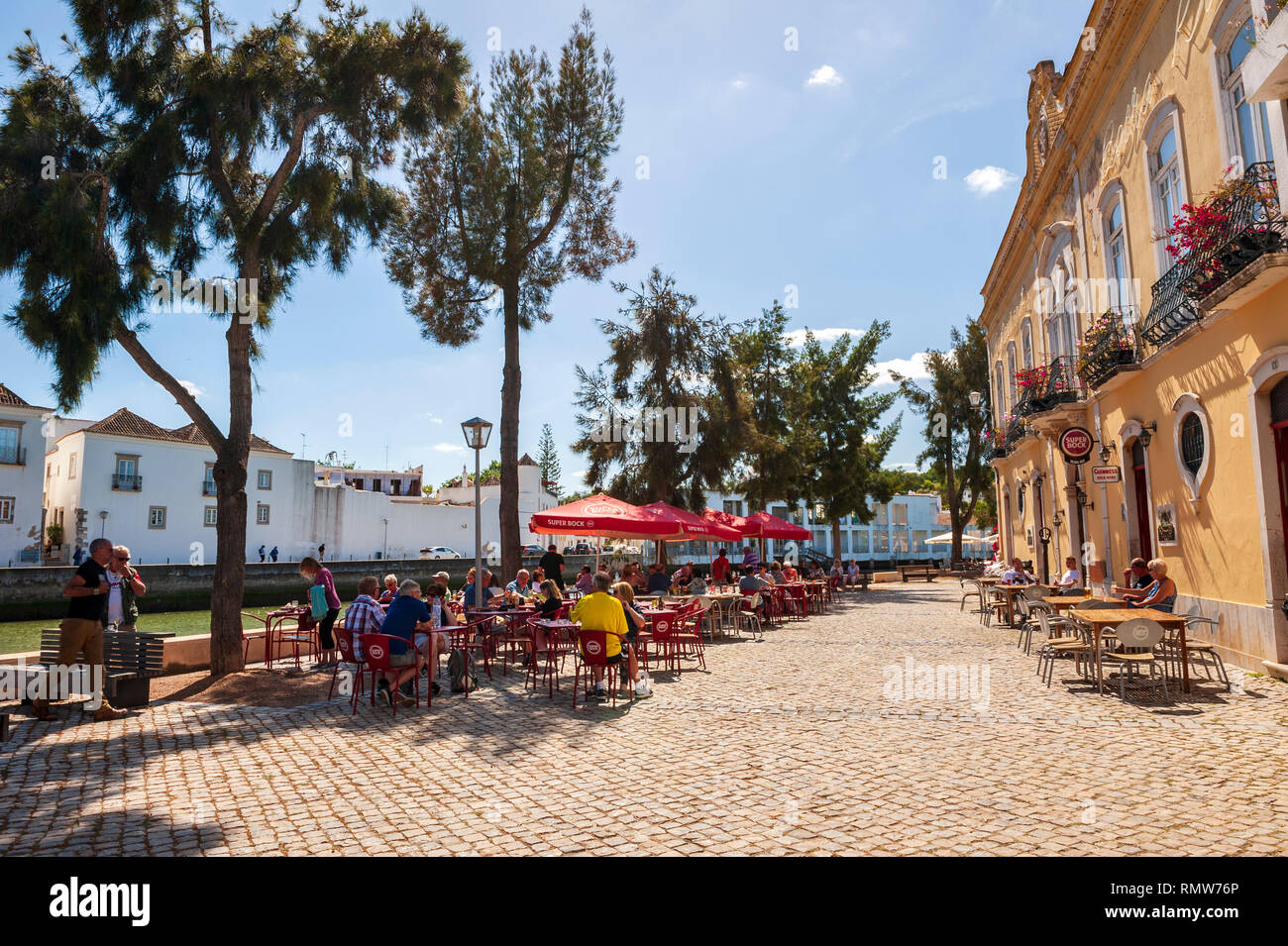 Tourists sitting by the Gilao River in Tavira, a Moorish- built town on the southern coast of Portugal. Algarve, Portugal. Stock Photo