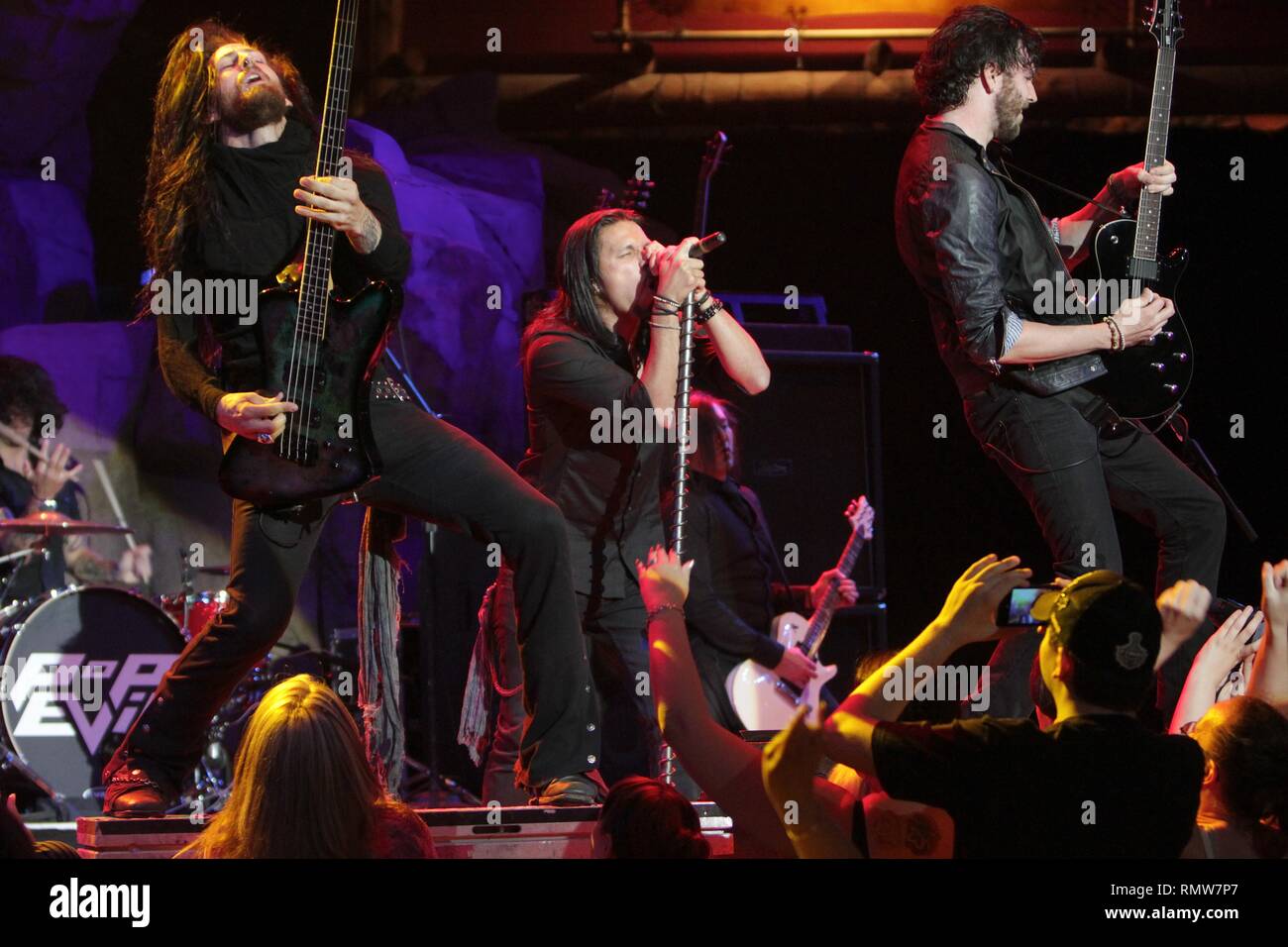 Pop Evil band members are shown performing on stage during 'live' concert appearance. Stock Photo