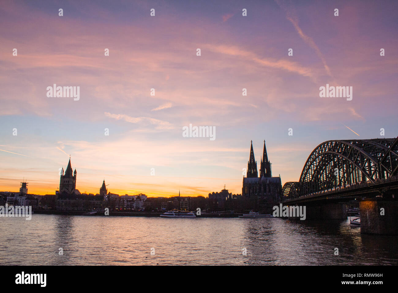 Panoramic view of Cologne, Germany with Cologne Cathedral, Hohenzollern Bridge and Old Town at sunset with beautiful colored sky Stock Photo