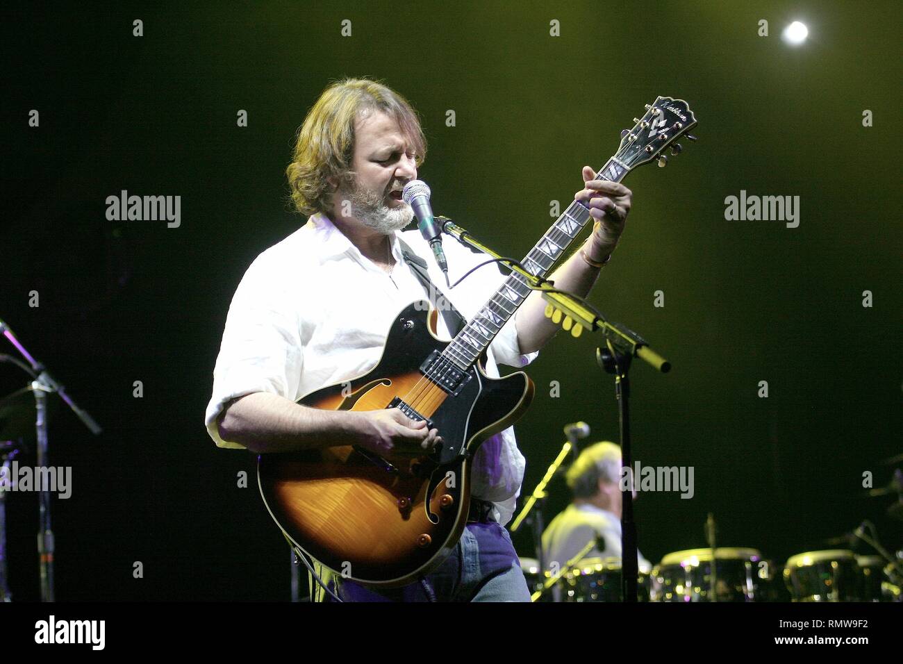 Lead singer and rhythm guitarist, John Bell, of the southern rock band Widespread Panic, is shown performing on stage during a 'live' concert appearance. Stock Photo