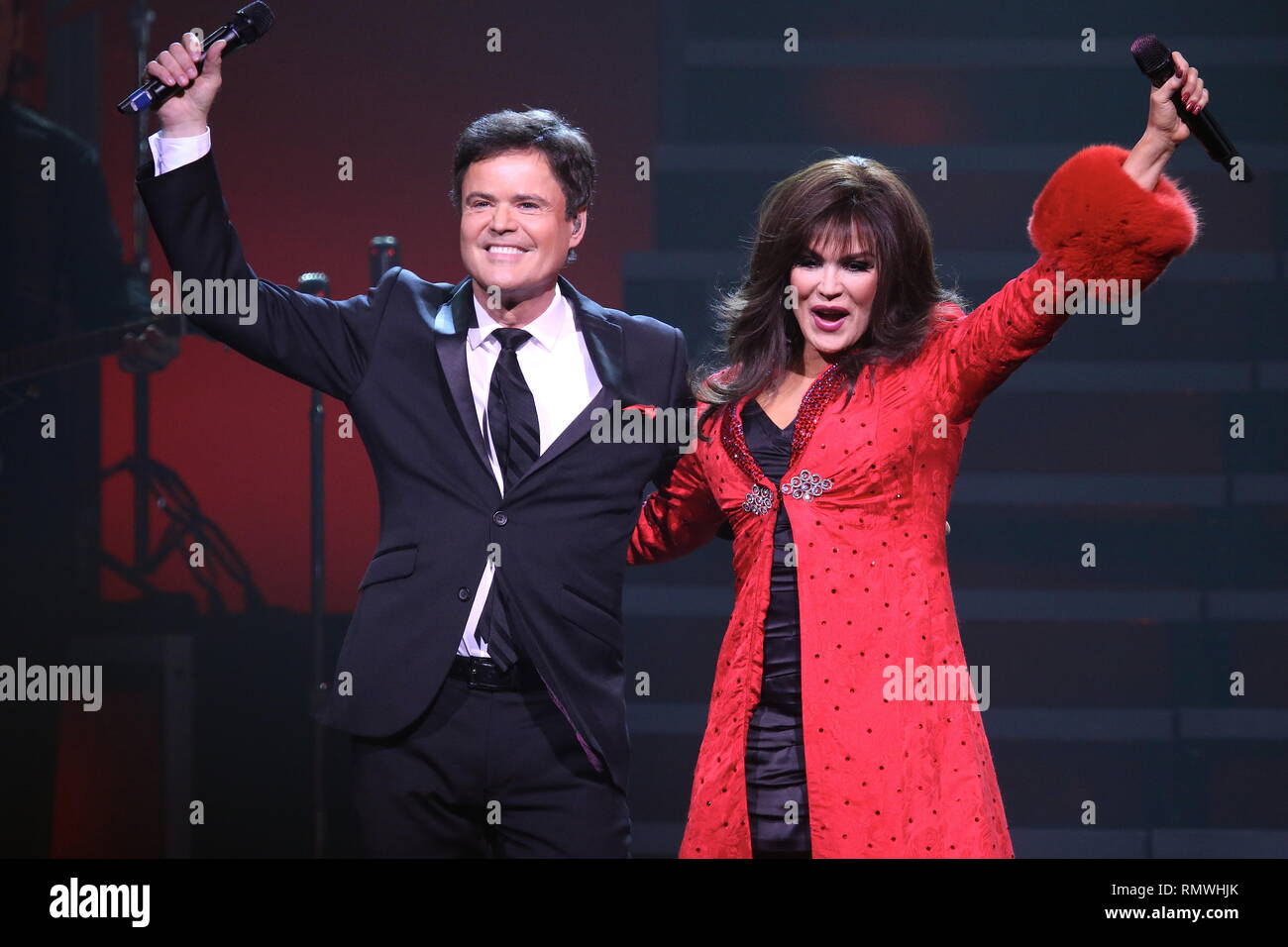 Entertainers Donny and Marie Osmond are shown performing on stage during a 'live' holiday concert show. Stock Photo