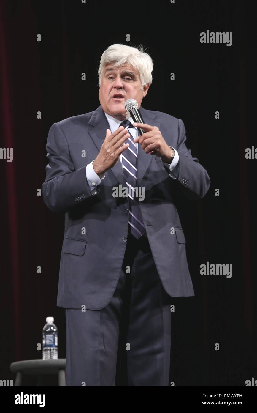 Comedian and television host, Jay Leno is shown performing on stage during a 'live' concert appearance. Stock Photo