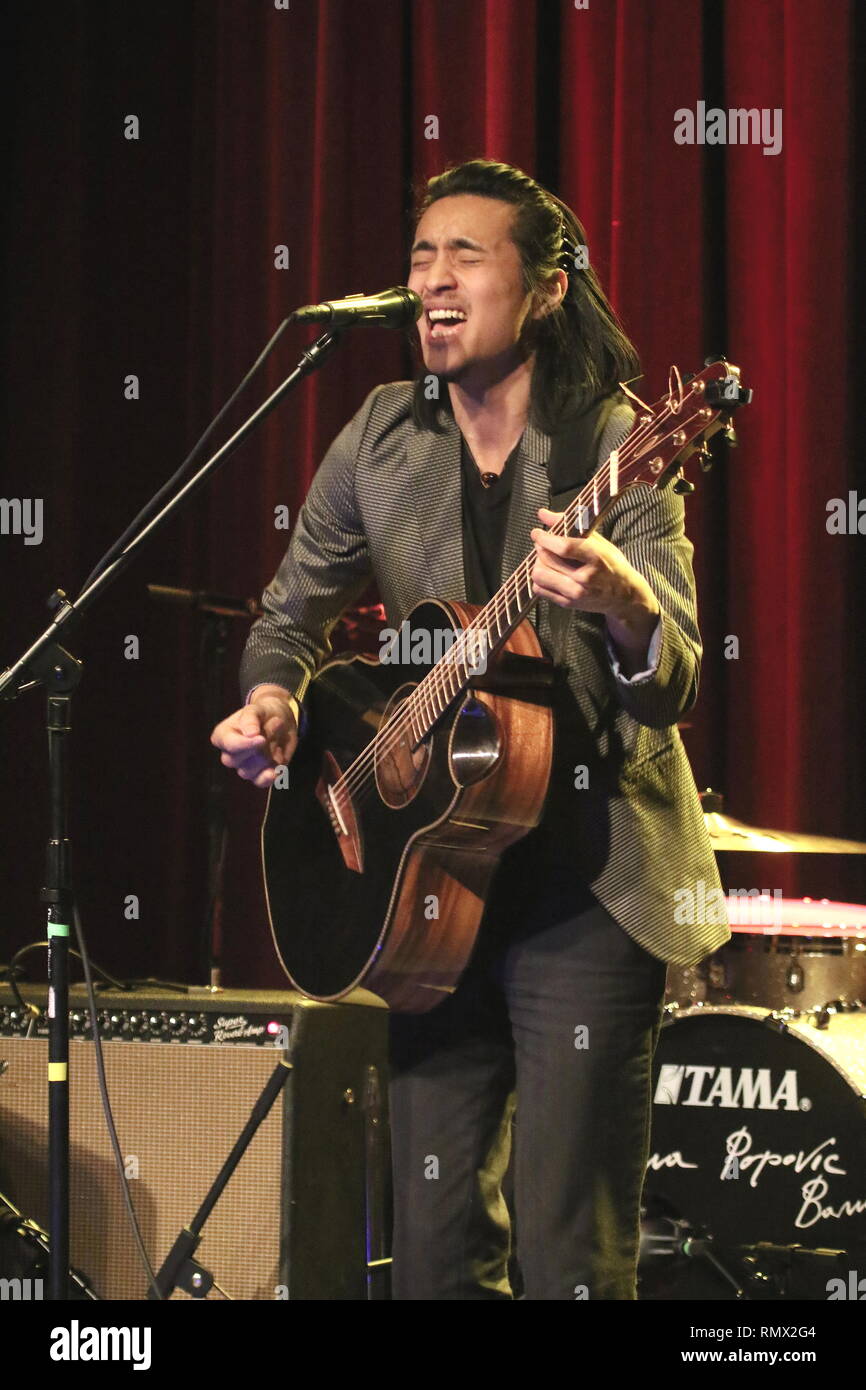 Guitarist, singer and songwriter Shun Ng is shown performing on stage during a 'live' concert appearance. Stock Photo