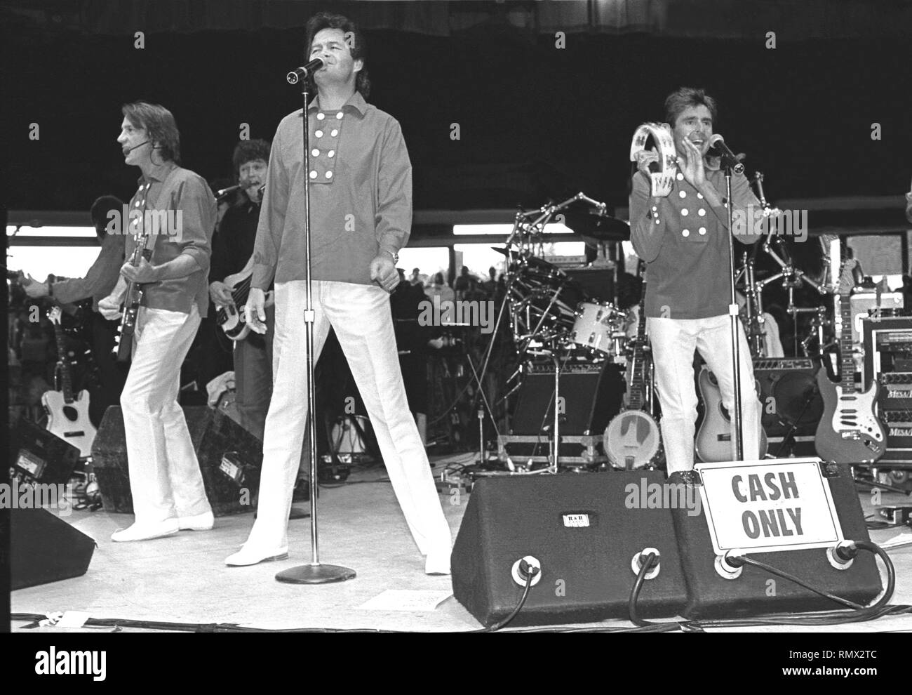 The Monkees are shown performing on stage during a 'live' concert appearance. Stock Photo