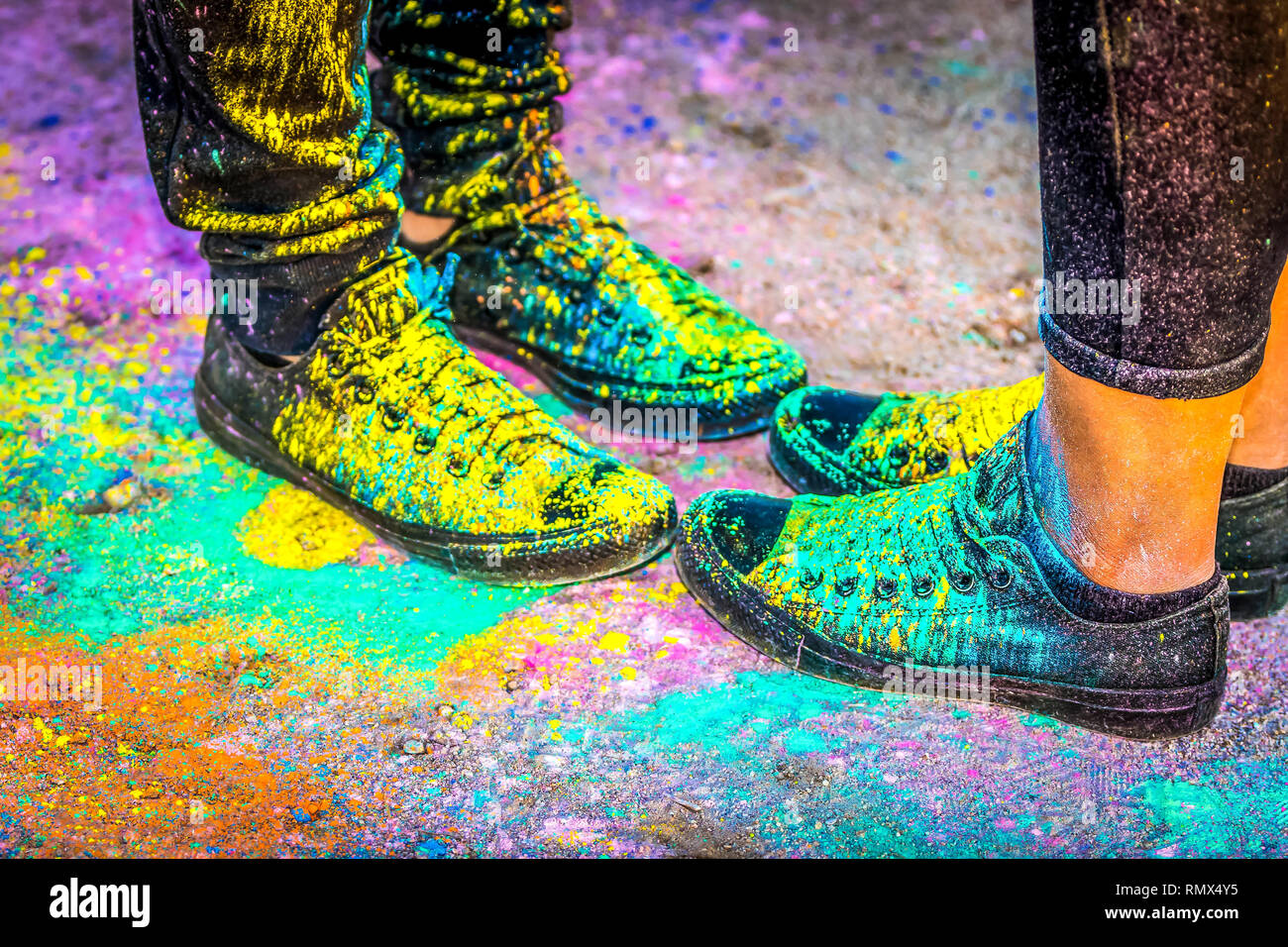 Black running shoes covered in colorful powder paint Stock Photo Alamy