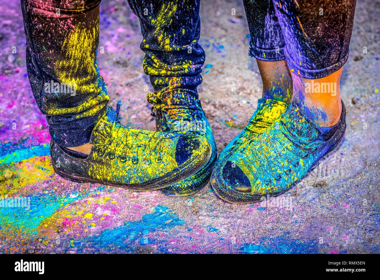 Black running shoes covered in colorful powder paint Stock Photo