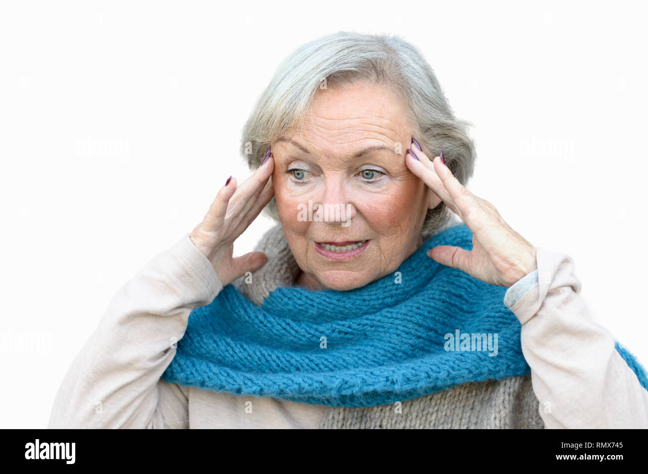 Confused and bewildered senior lady holding her hands to her temples as she looks aside, conceptual of the onset of dementia or Alzheimers disease Stock Photo