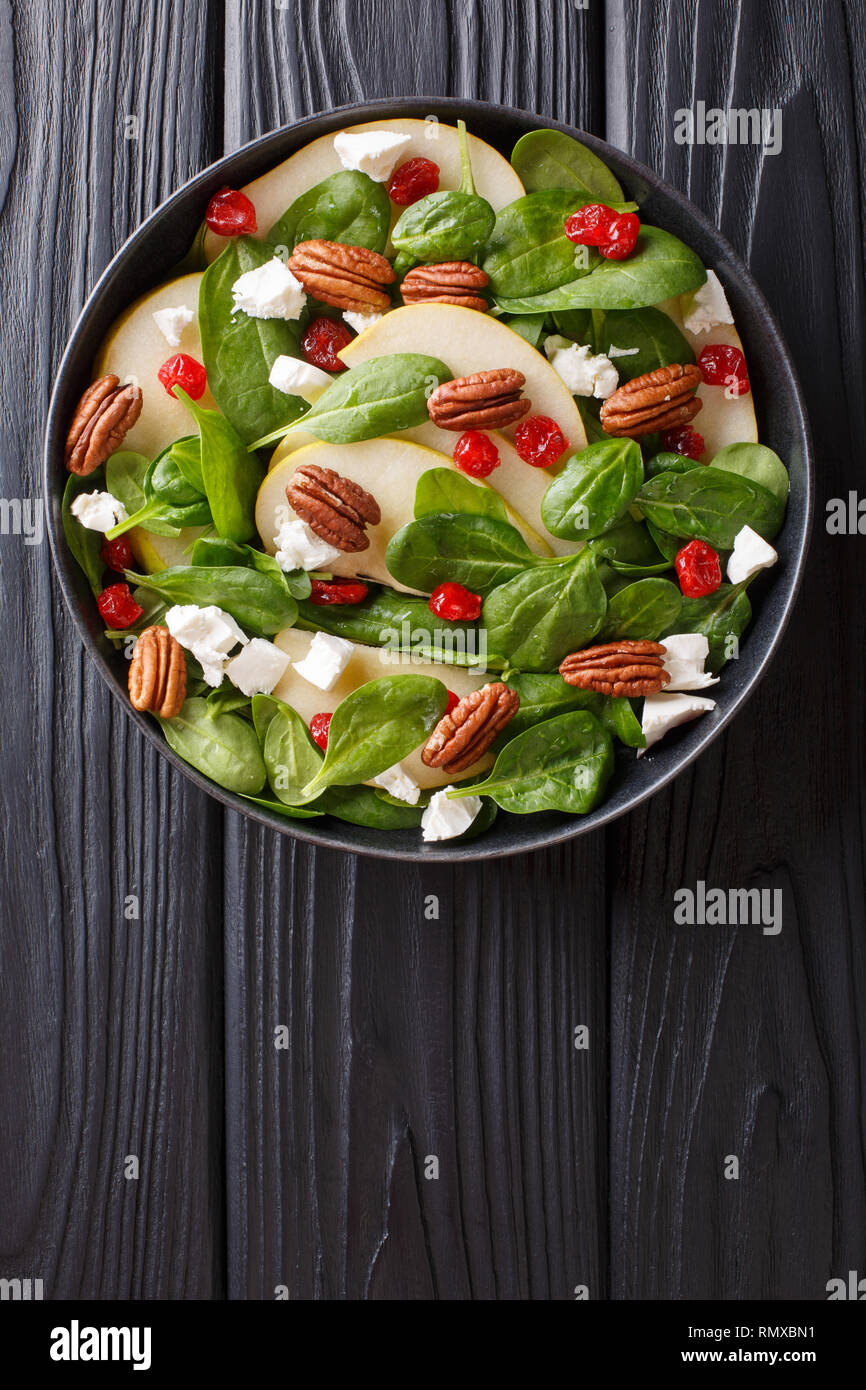 Dietary raw salad of pears, spinach, pecans, goat cheese and dried