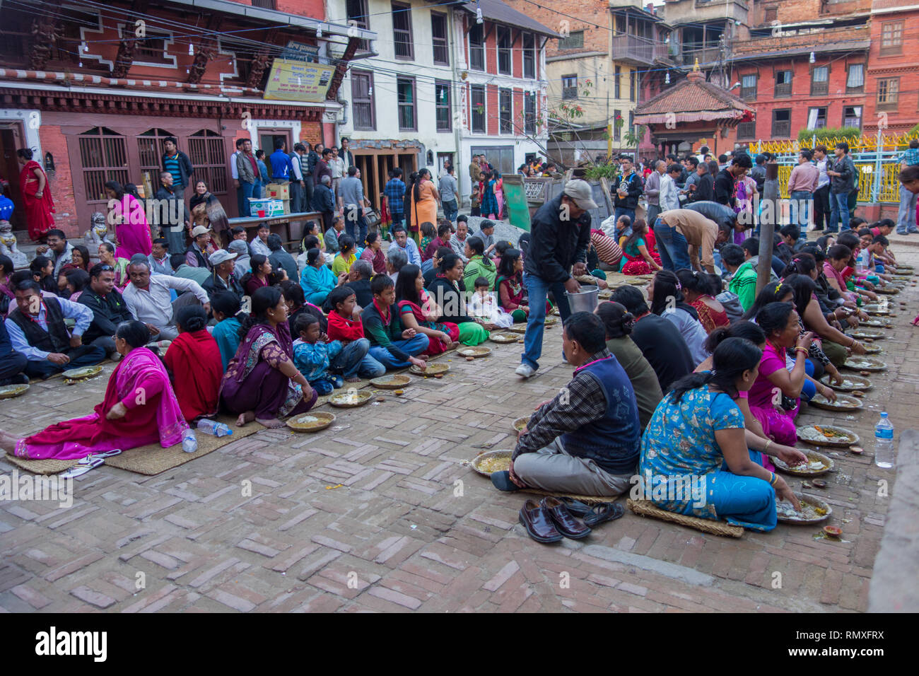 GOLDEN TEMPLE, KATHMANDU, NEPAL-CIRCA 2013 : Nepalese wait for religious meal offered by a local Hindu temple in Kathmandu, Nepal Stock Photo