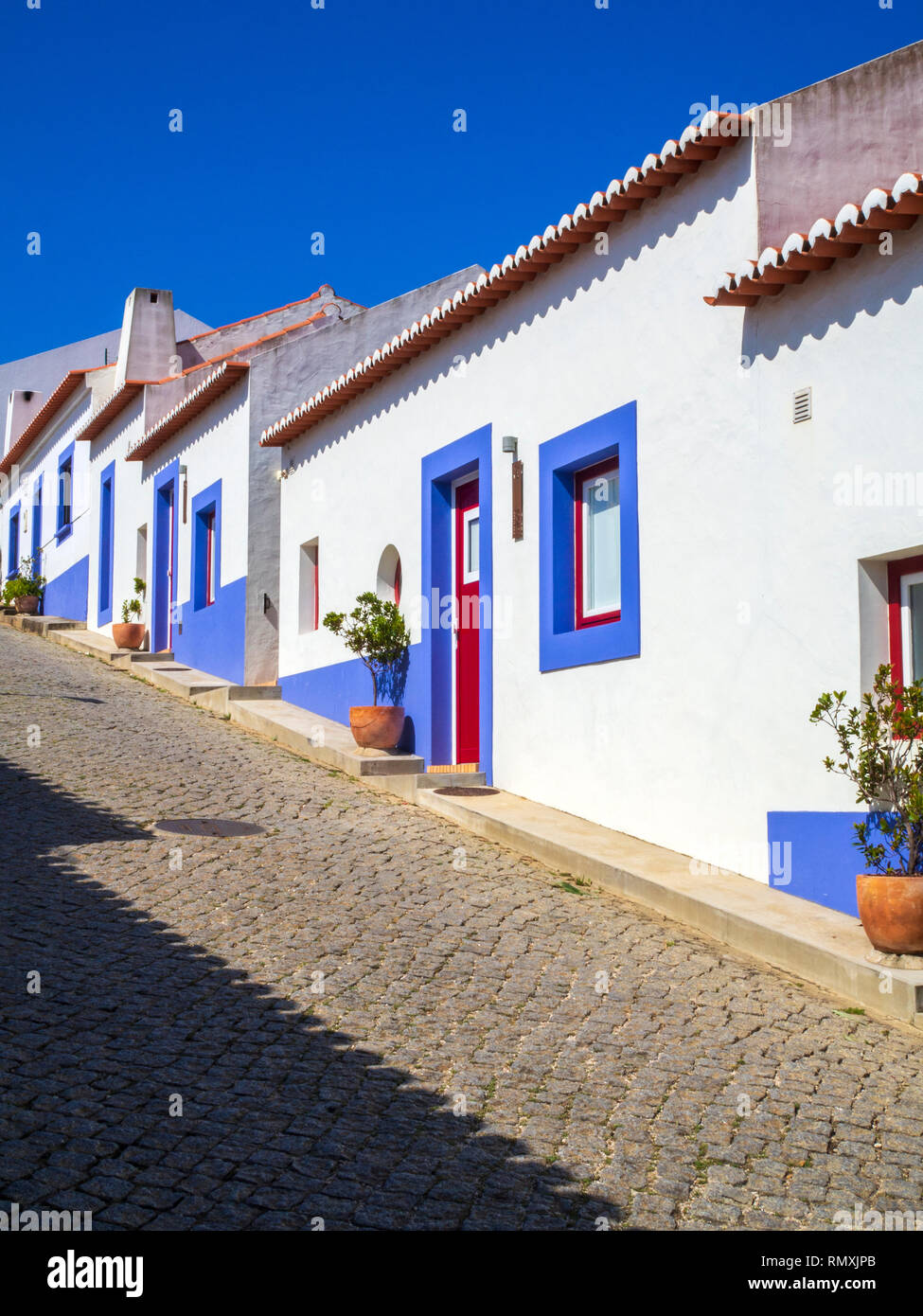 Quaint blue and white houses line a street in Odeceixe, a small town in the northern Algarve, southern Portugal. Stock Photo