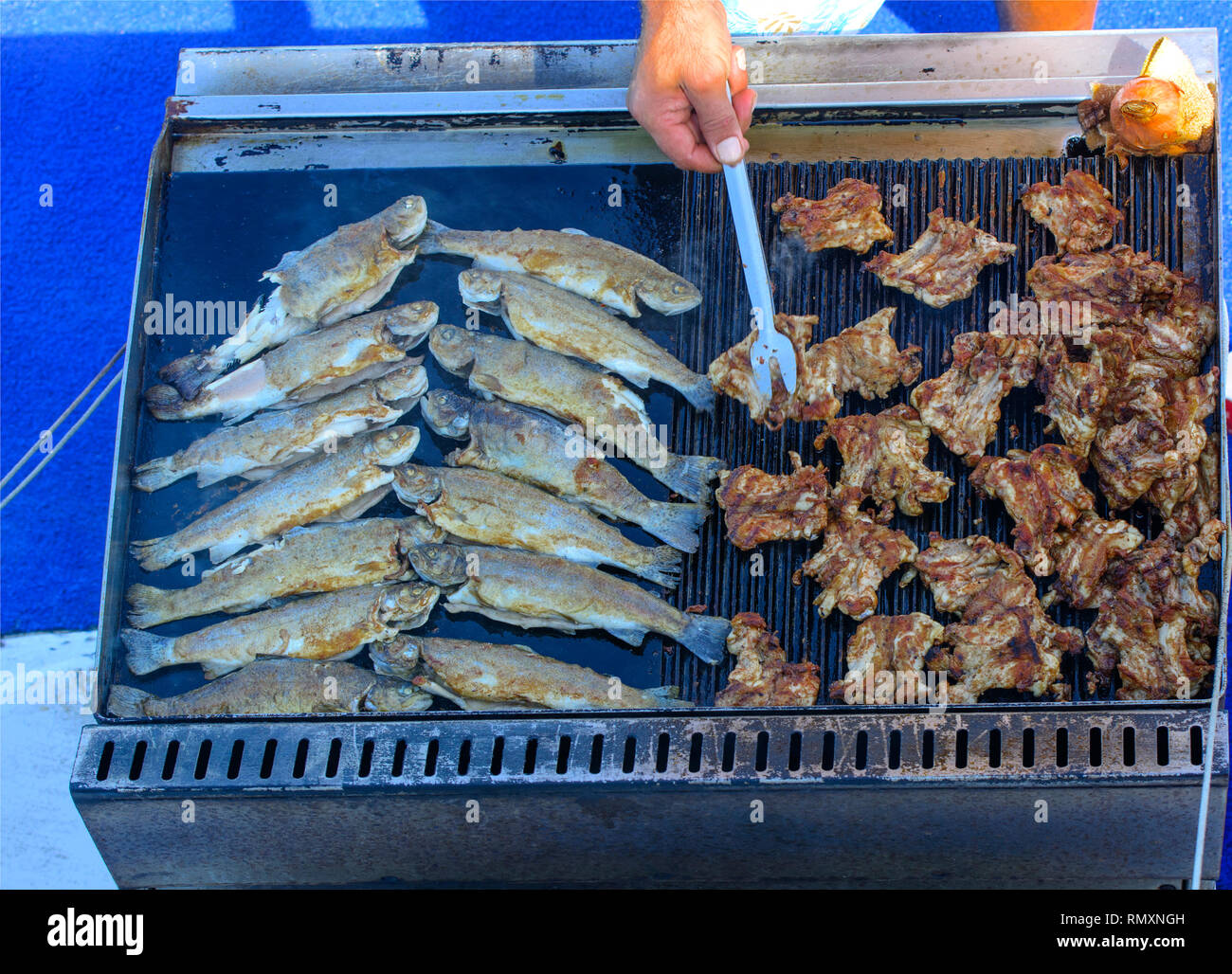 Beautifully cooked fried pieces of quail meat and whole trout fish on
