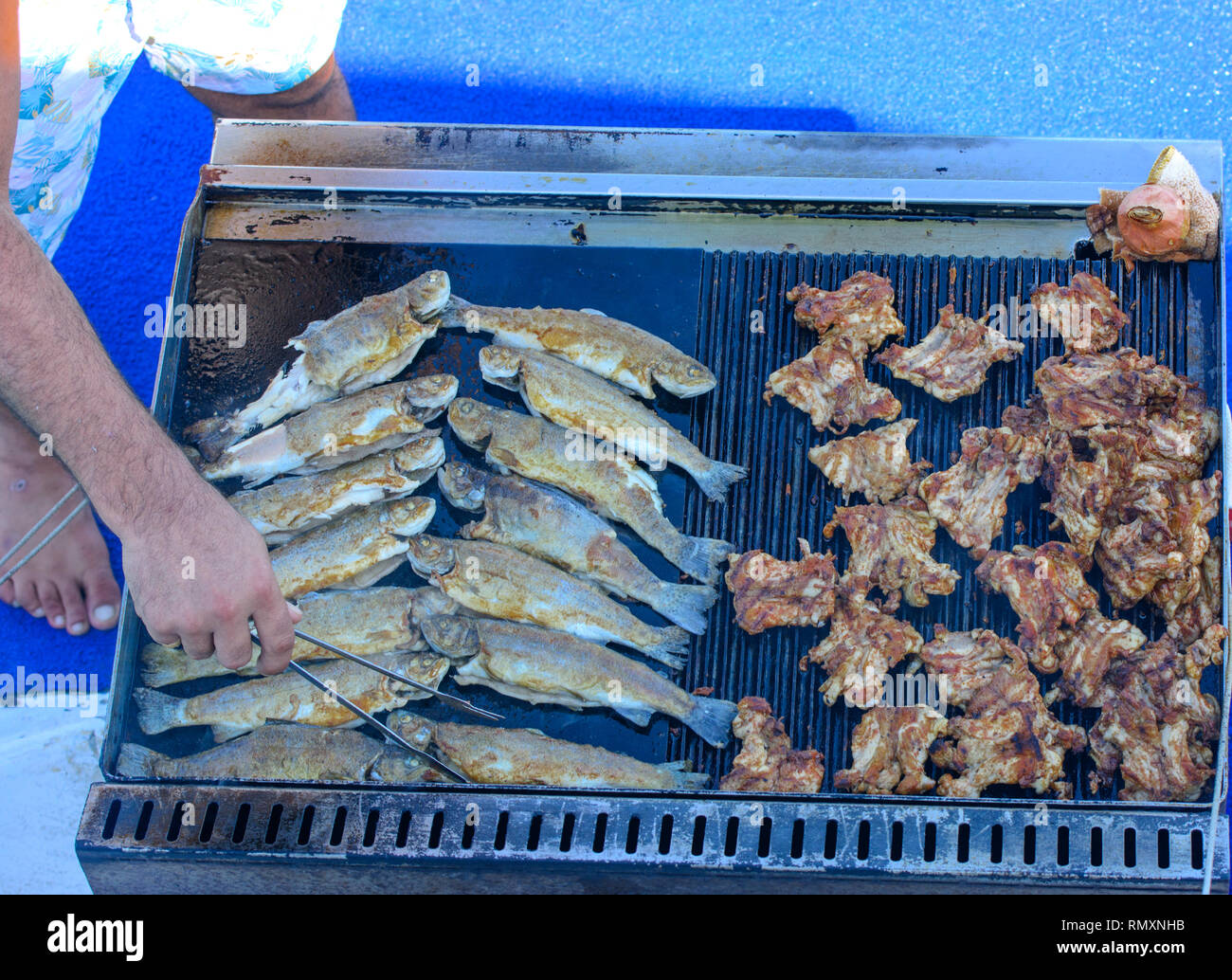 Beautifully cooked fried pieces of quail meat and whole trout fish on an electric  grill on a yacht in the open sea. The concept of fast cooking delici Stock  Photo - Alamy
