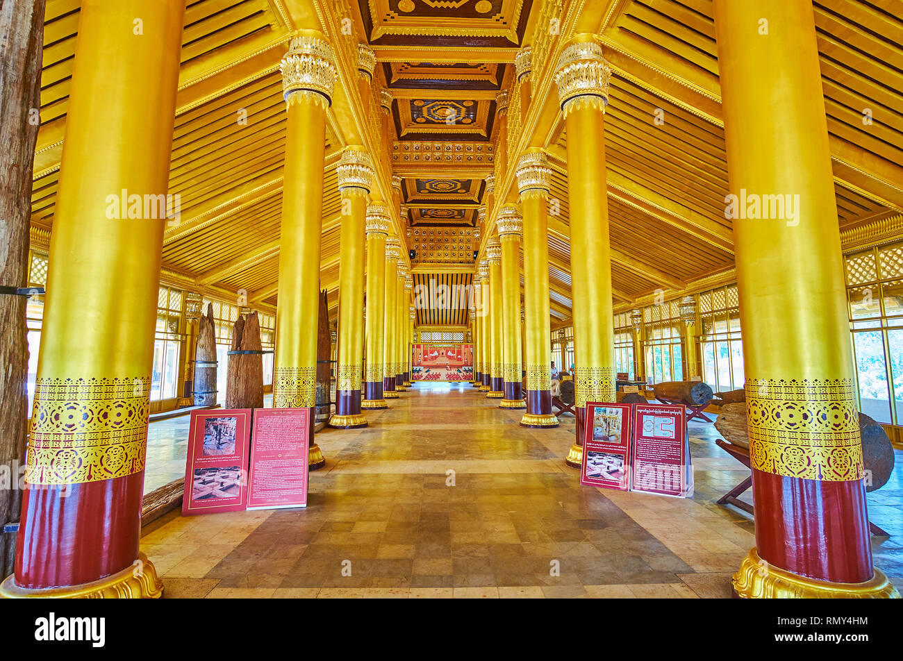 BAGO, MYANMAR - FEBRUARY 15, 2018: The splendid interior of restored wooden Kanbawzathadi Golden palace with lines of tall coumns and carved ceiling,  Stock Photo