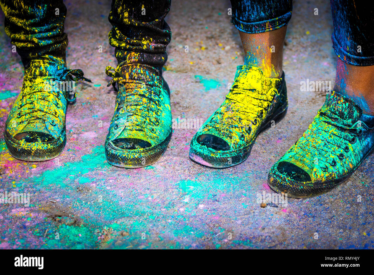 Black running shoes covered in colorful powder paint Stock Photo Alamy