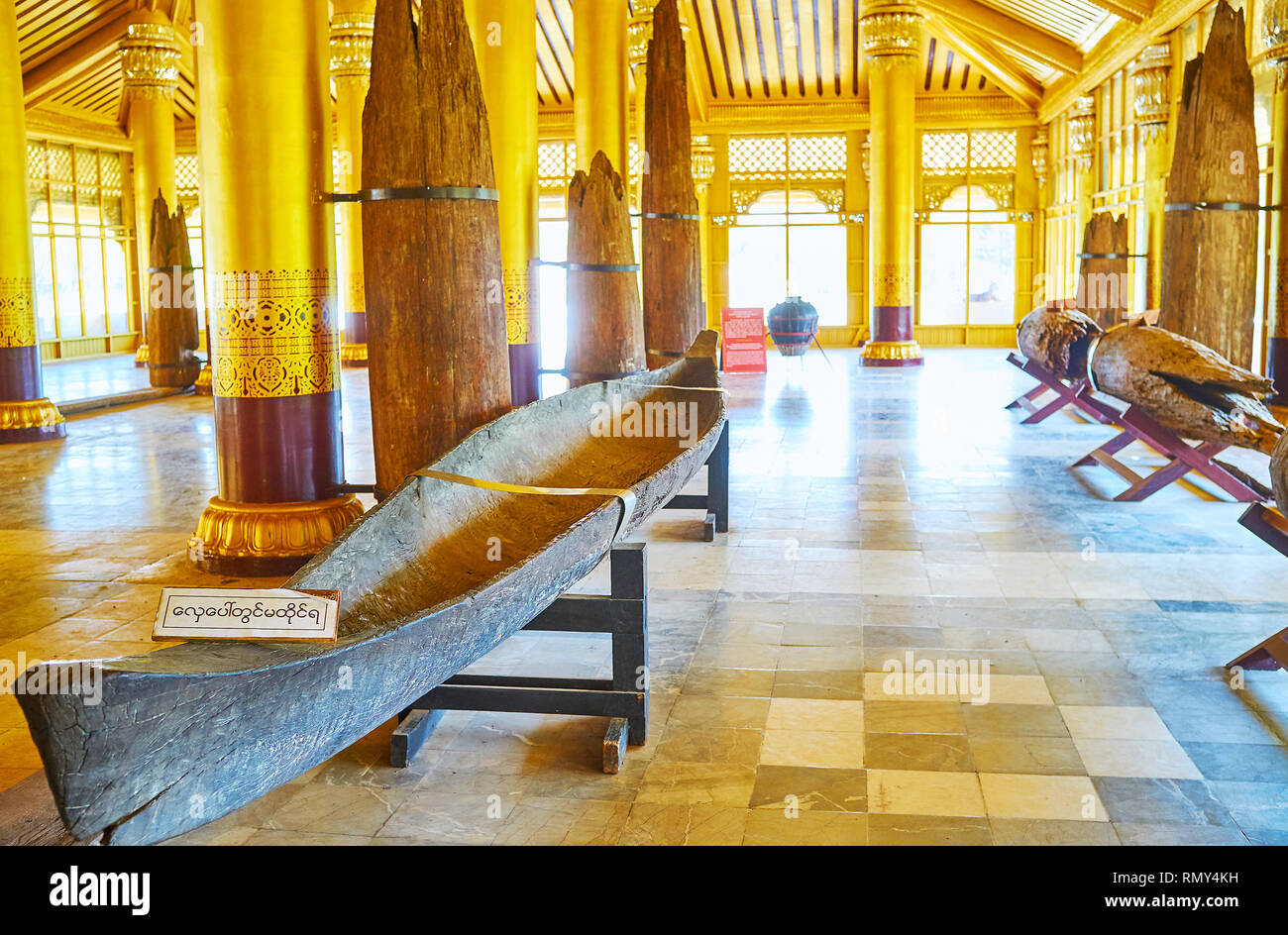 BAGO, MYANMAR - FEBRUARY 15, 2018: The ruins of teak pillars and medieval kayak in museum of Kanbawzathadi Golden palace, located in Lion Throne Hall, Stock Photo