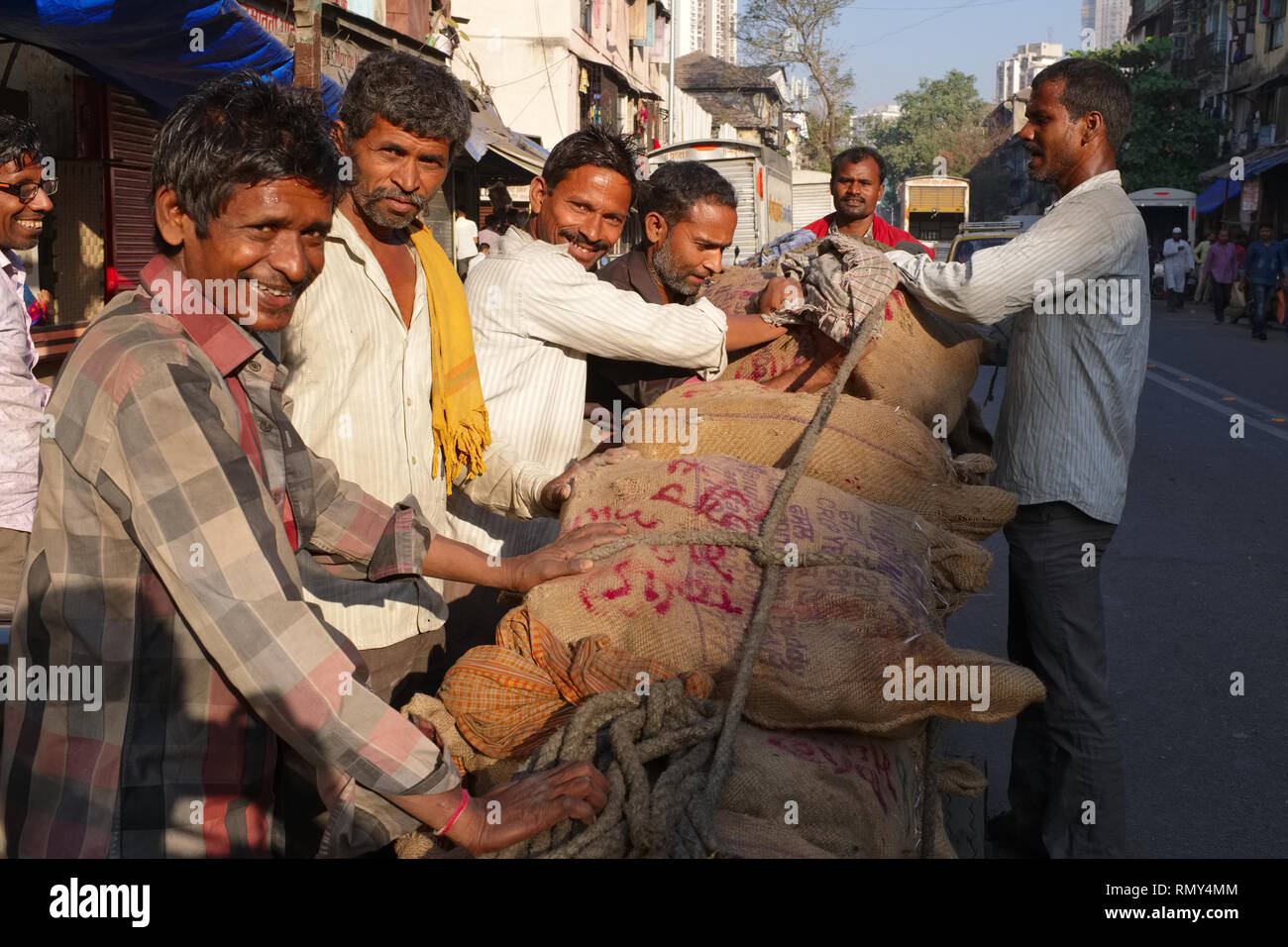 Handcart pullers, migrants from Uttar Pradesh in Northern India, pushing and pulling a two ton load of metal; seen in Khetwadi area, Mumbai, India Stock Photo