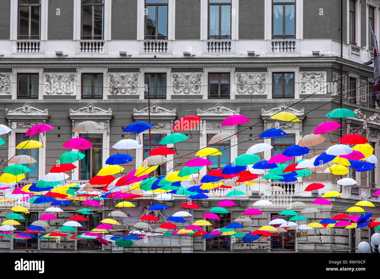 coloful suspended umbrellas hanging n black and white building background . Stock Photo