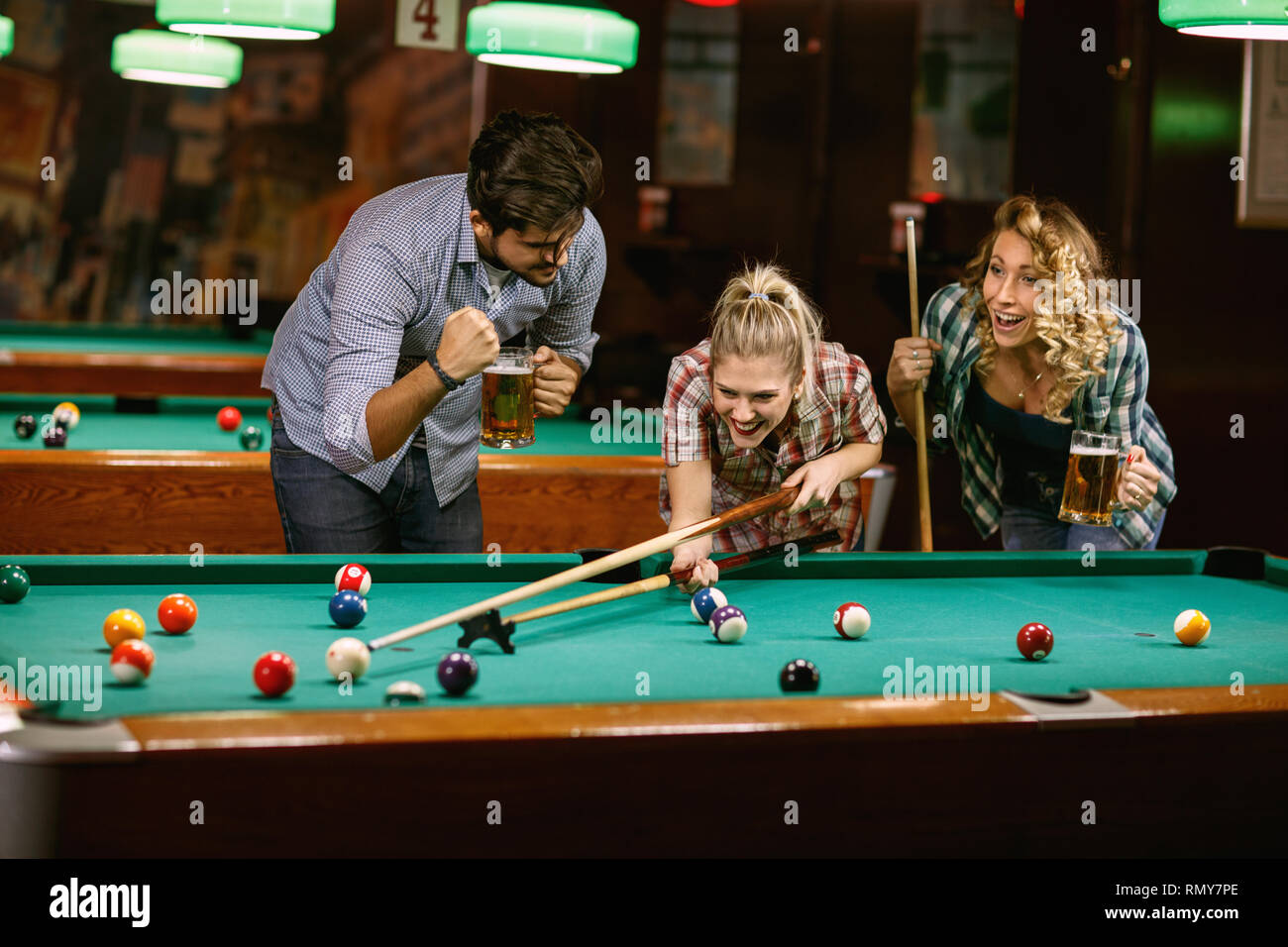 Group of friends playing pool game in pub Stock Photo