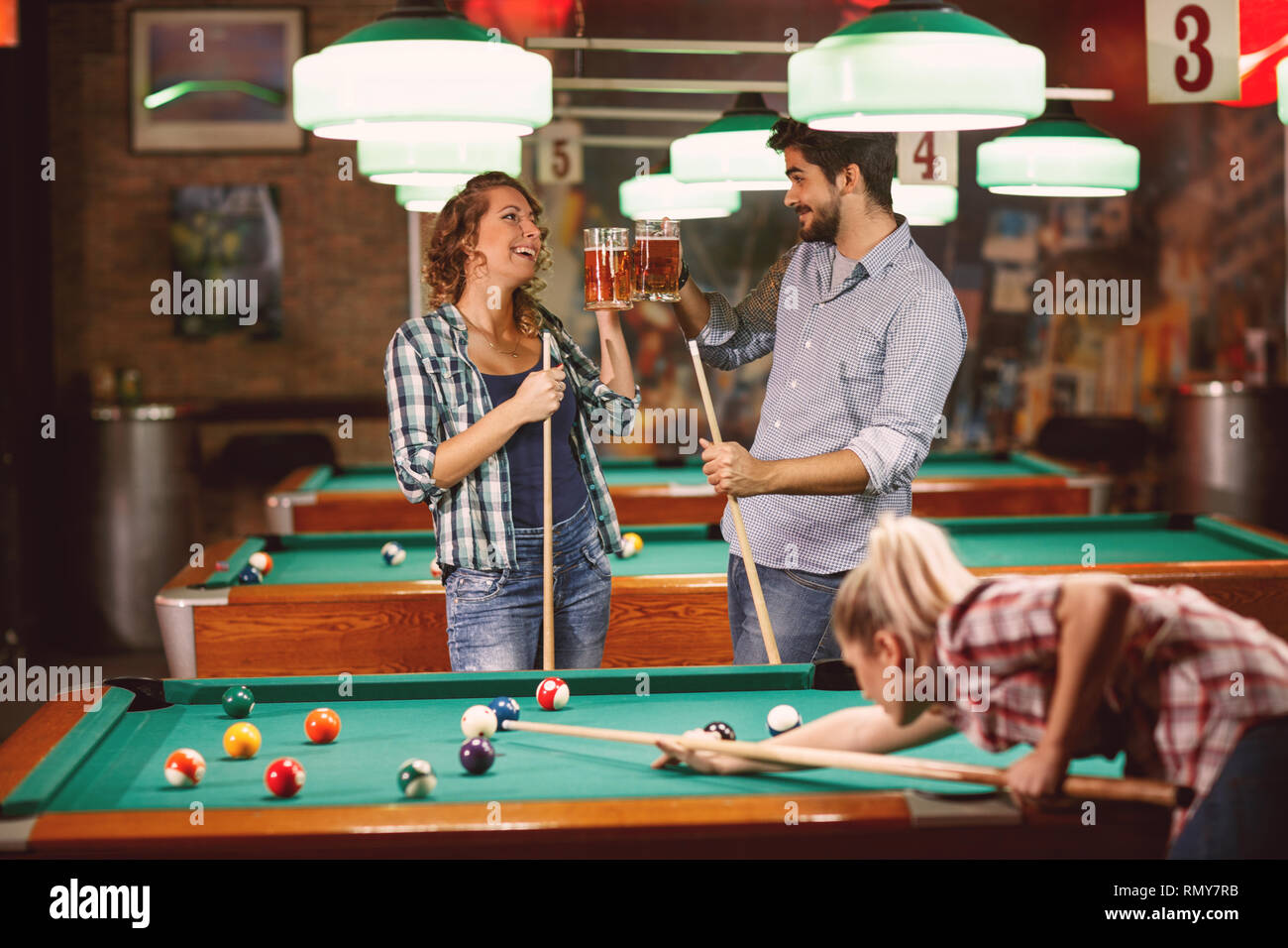 Young smiling friends playing snooker or billiard Stock Photo