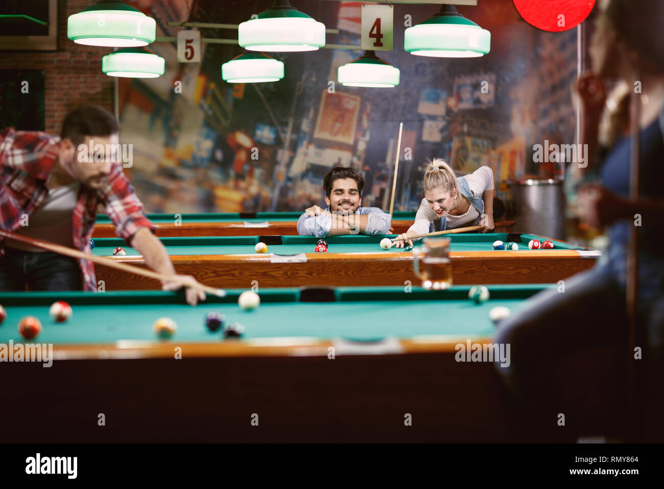 billiard games Happy friends enjoying playing pool together Stock