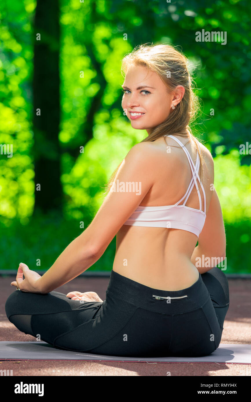 yoga asanas - view of the back of a woman in the lotus position in the ...