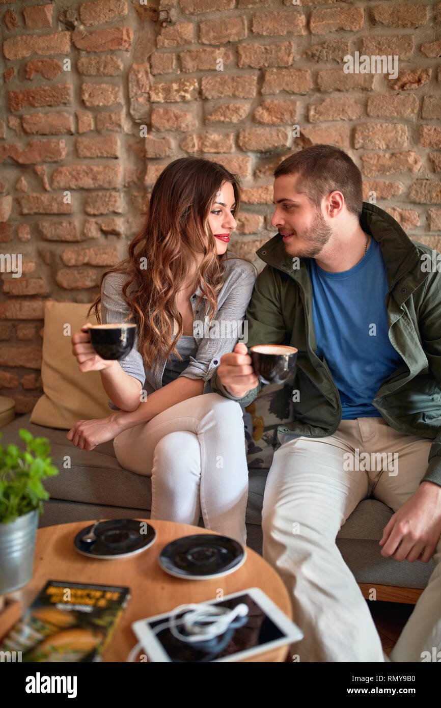 Attractive couple talking and drinking aromatic coffee in cafeteria Stock Photo