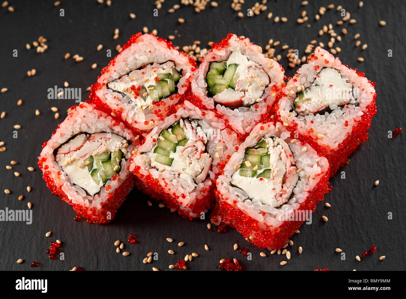 View from above of california roll with crab meat, cucumber and cream cheese. Sushi uramaki covered with red flying fish roe. Stock Photo