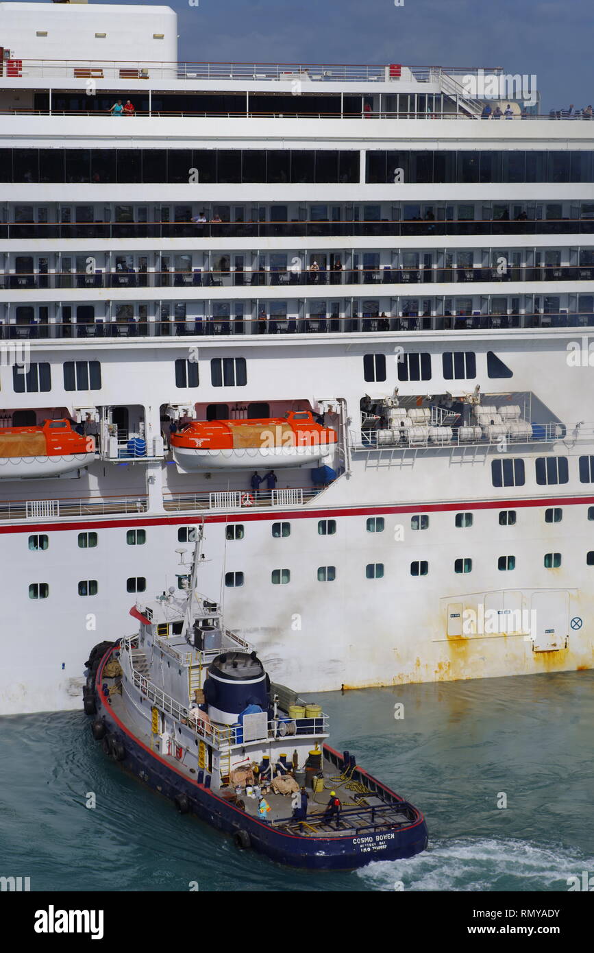Tug Cosmo Bowen helping Carnival Freedom into dock Stock Photo