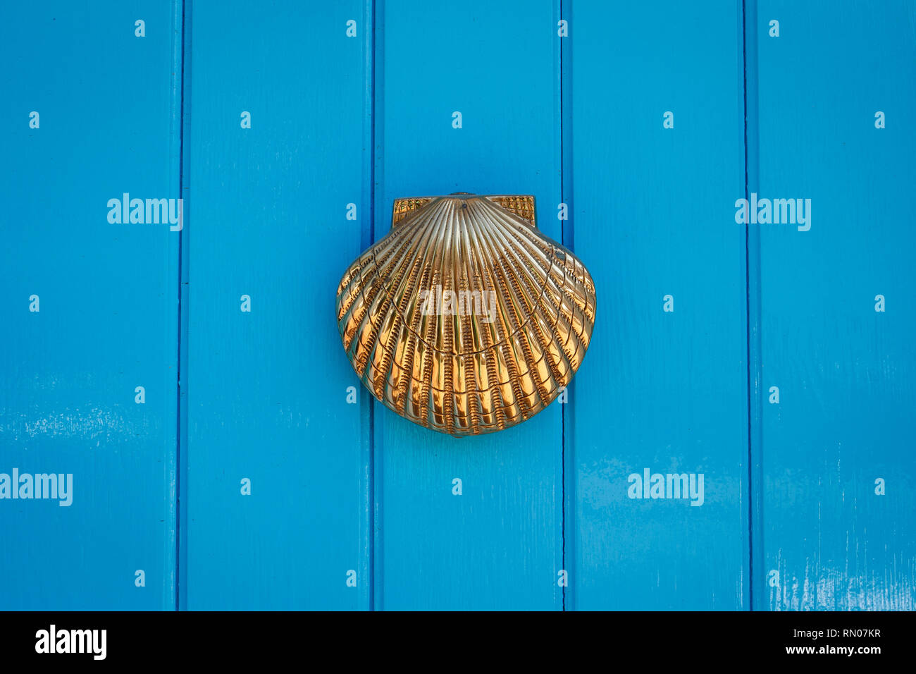 Picture of aDoor with brass knocker in the shape of a shell, beautiful entrance to the house, vintage decoration. Maro, near Marbella, Spain. Stock Photo